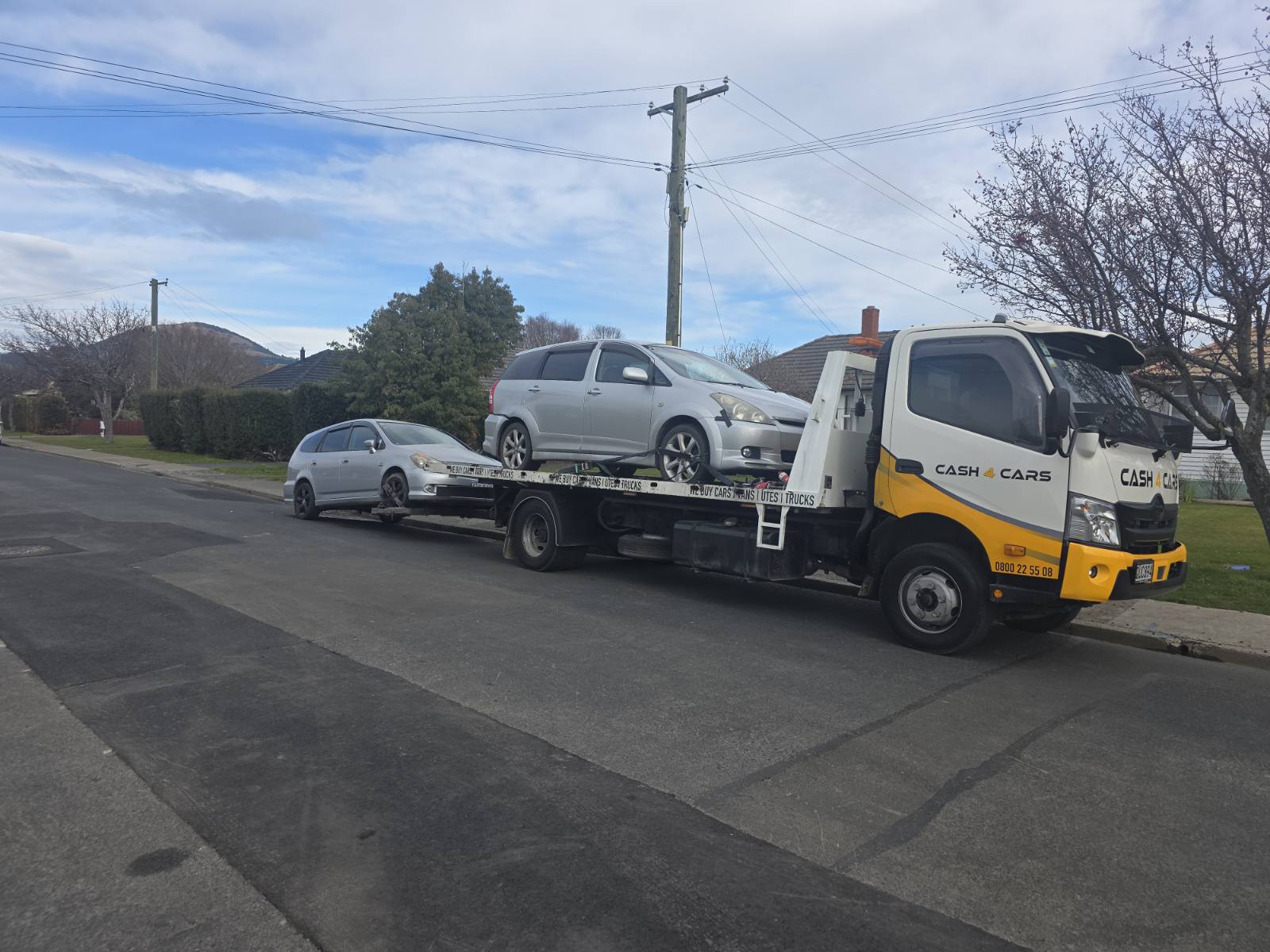 Cash 4 Cars tow truck loaded with two silver cars on an Invercargill street